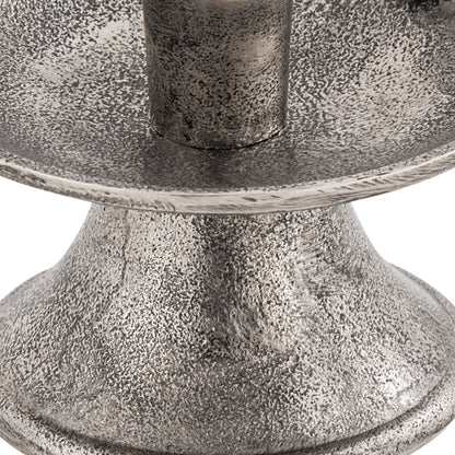 Close-up of a textured metal candle holder on a white background