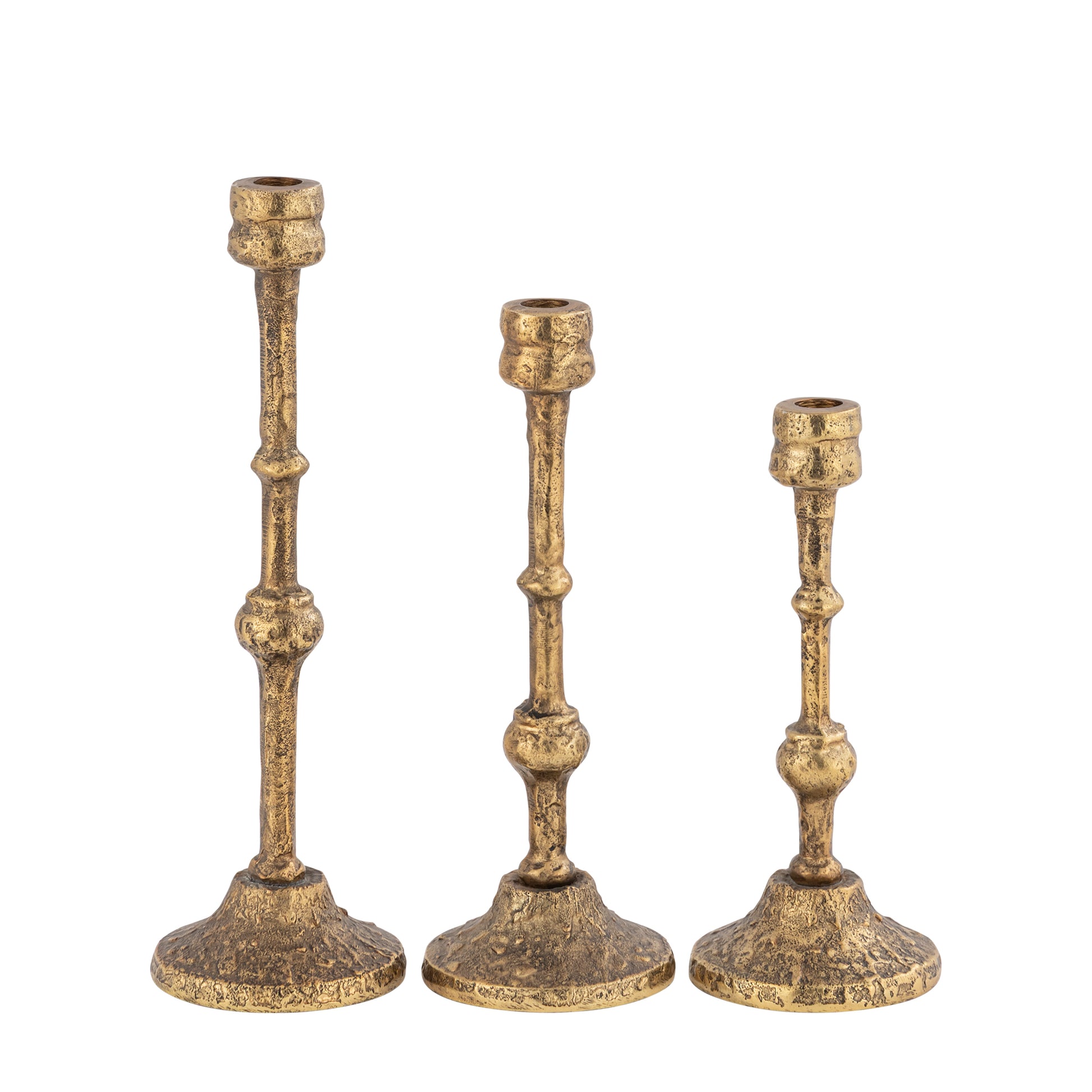 Three gold candle holders of varying heights on a white background