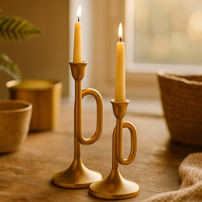Two gold candle holders with lit candles
