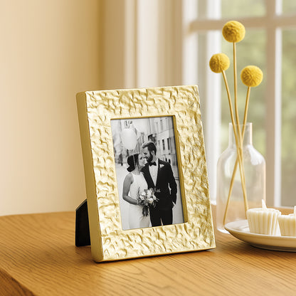 Gold textured picture frame with a photo of a couple