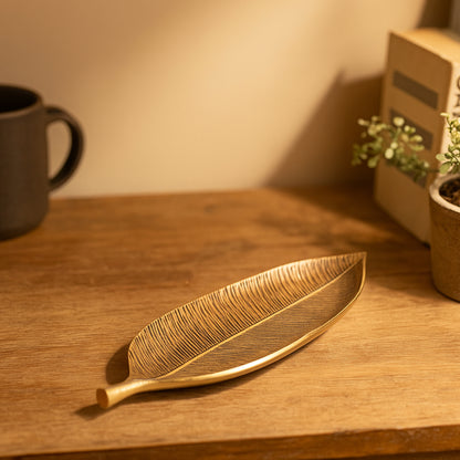 Gold leaf-shaped tray on a wooden surface